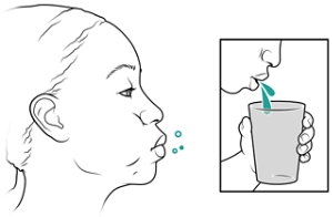 Person rinsing mouth and spitting into cup.