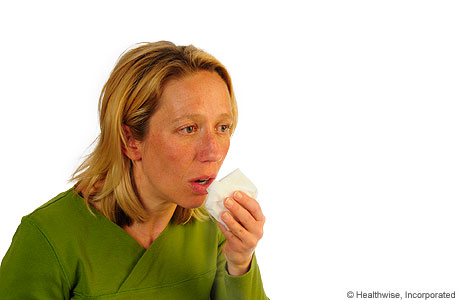 Una mujer tosiendo para aflojar la mucosidad