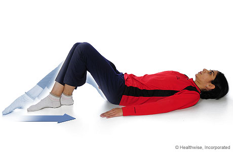 Una mujer haciendo un ejercicio de flexión de rodillas con deslizamiento de talón