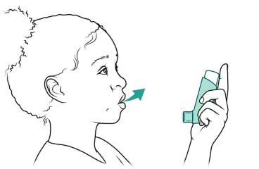 Child exhaling while holding inhaler.