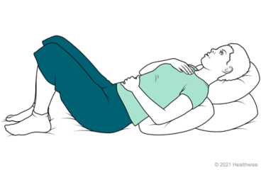 Respiración abdominal mientras se reclina sobre almohadas.