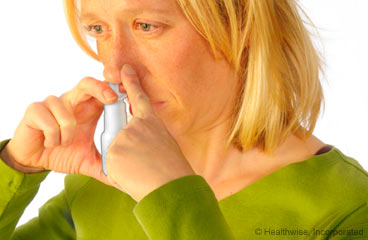 Mujer usando un aerosol nasal