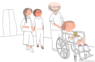 The nurse pushes Hank in a wheelchair while Hank's parents follow The nurse pushes Hank in a wheelchair while Hank's parents follow