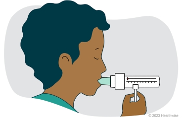 A child with the peak flow meter mouthpiece in their mouth.