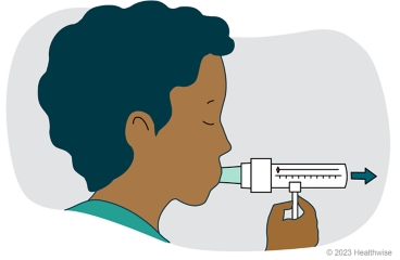 A child breathing out hard into the peak flow meter.