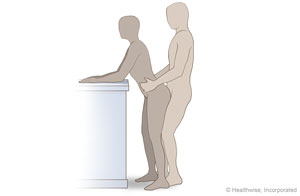 Couple standing, both facing forward, with person behind their partner.