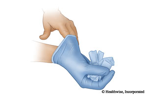 Con la mano enguantada, haga una bola con el guante que se ha quitado y a continuación deslice uno o dos dedos desnudos dentro del segundo guante para que pueda quitárselo