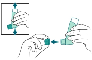 Person shaking inhaler and removing cap.