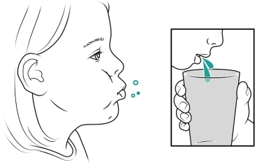 Child rinsing mouth and spitting into cup.