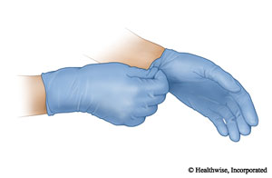 Use una mano para agarrar el puño del otro guante