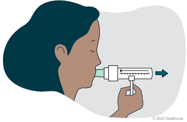 A person breathing out hard into the peak flow meter.