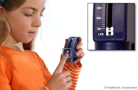 A child setting a peak flow meter to its lowest number