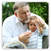 Abuelo soplando burbujas con su nieto