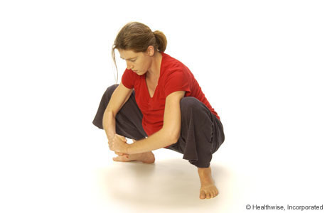 Person squatting, with each knee out to the side.