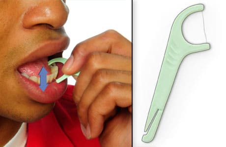 Person using a flossing tool to floss, moving floss up and down between two teeth.