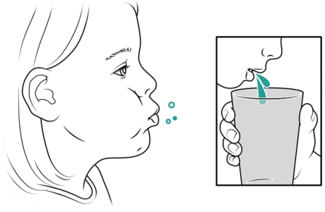 Child rinsing mouth and spitting into cup.